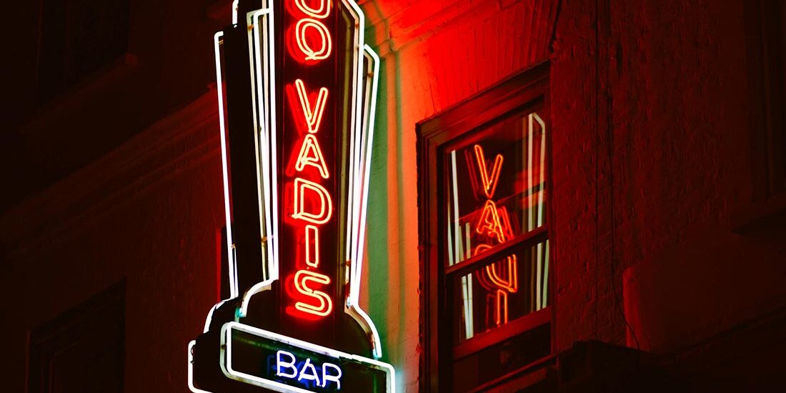 A neon sign for '80 Yards Bar' glowing red at night.