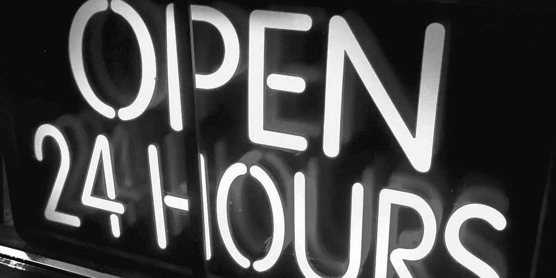 A neon sign reading 'OPEN 24 HOURS' in white light.