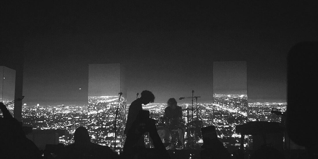 Silhouette of a person overlooking a city at night.